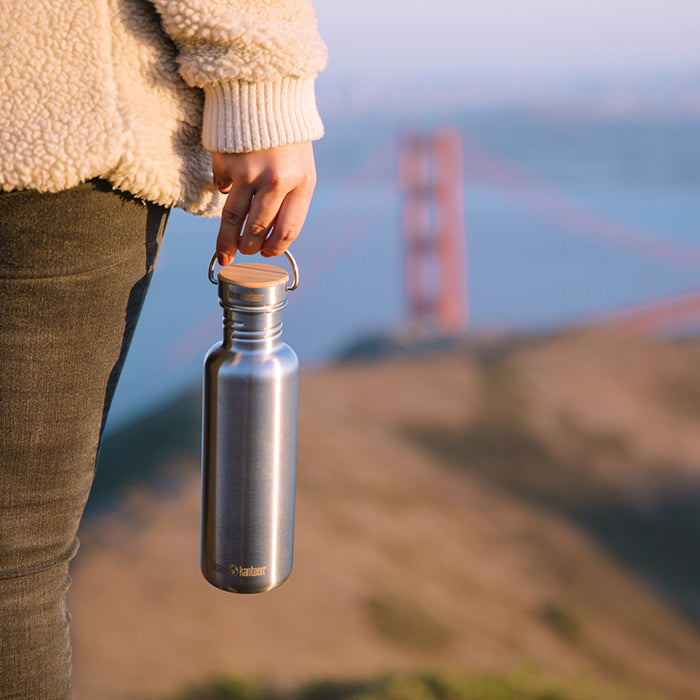 27oz-reflect-with-bamboo-cap-s8 K27SSLRF-BS-BAMBOO_reflect_bottle_bridge_lifestyle.jpg